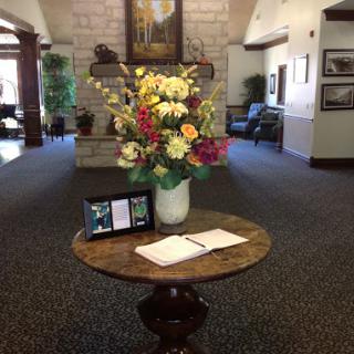 A welcoming lobby space featuring a beautiful floral arrangement and a table for notes.