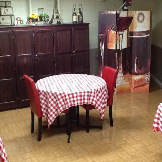A cozy restaurant interior with tables covered in red and white checkered tablecloths.