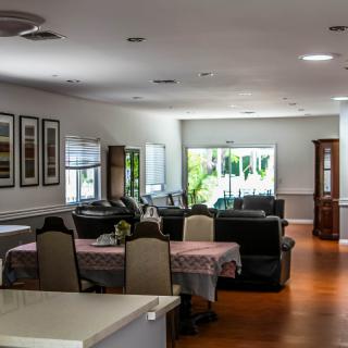 A spacious and well-lit living room with a dining area, showcasing modern interior design and comfortable furniture.