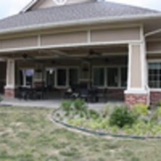 A backyard view of a house with a covered patio and garden.
