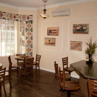 A charming caf� interior featuring wooden furniture and tasteful wall decorations.