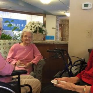 Elderly individuals engage in a conversation in a community setting.