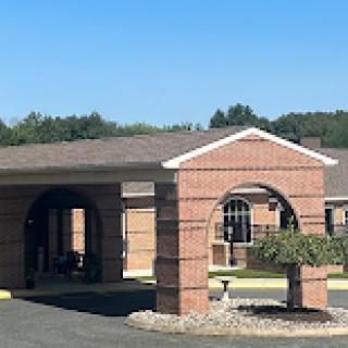 A well-designed brick entrance of a building under a clear blue sky.