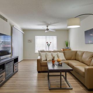 A modern living room with a large sofa, flat-screen TV, and stylish decor.