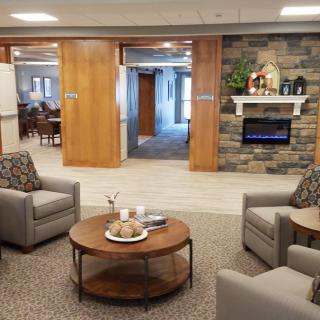 A modern lounge with comfortable seating and a stone fireplace.
