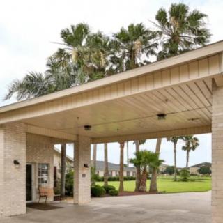 A building entrance with palm trees in the background.