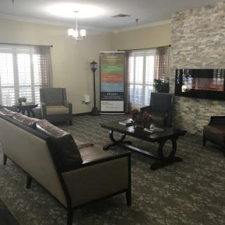 A cozy and modern living room with elegant furniture and a natural stone accent wall.