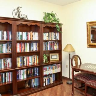 A cozy reading nook with a well-stocked bookshelf and a small desk.