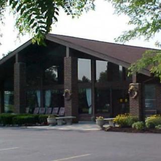 A modern building with large windows surrounded by trees.