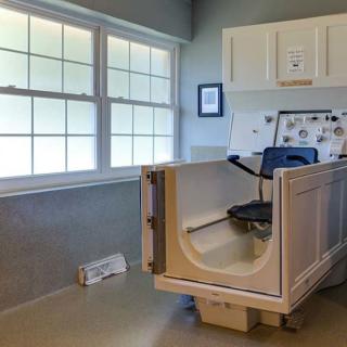 A senior-friendly bathroom featuring an accessible walk-in tub with a safety seat.