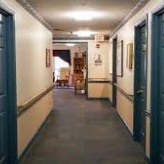 A hallway with multiple doors and a seating area at the end.