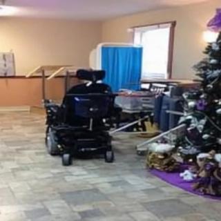 An indoor space with a wheelchair, medical equipment, and a decorated Christmas tree.