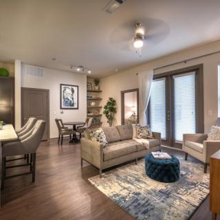 A modern living room with a cozy seating area, elegant decor, and an open dining space.