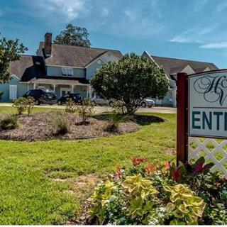 A beautiful house with a landscaped garden and an entrance sign.