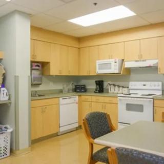 A view of a kitchen with wooden cabinets and various appliances.