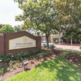 Entrance of College Park Apartment Homes with a visible sign and surrounding greenery.