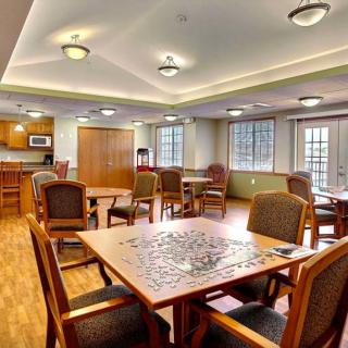 A cozy room with several tables and chairs, featuring a puzzle in progress.
