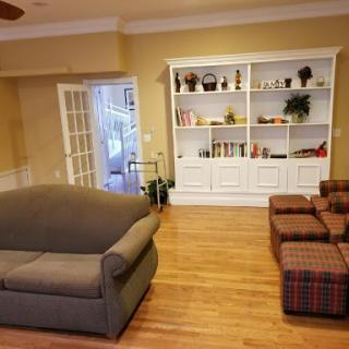 A cozy living room featuring a comfortable sofa, a stylish bookshelf, and warm wooden flooring.