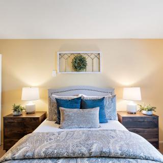 A cozy bedroom with a neatly made bed and matching nightstands.