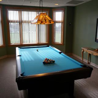A well-lit game room featuring a blue pool table, perfect for recreational activities.