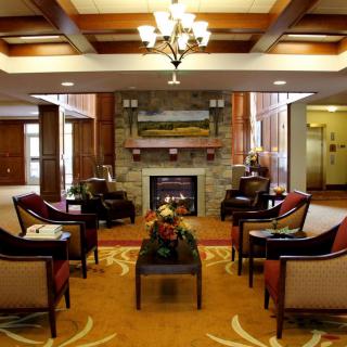 A cozy lounge area featuring a central fireplace surrounded by comfortable seating.