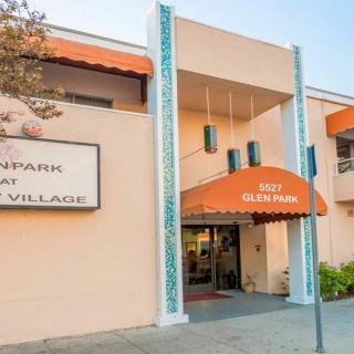 The entrance to a building featuring an orange awning and a large sign.
