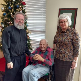 A family gathered around a Christmas tree, celebrating together.
