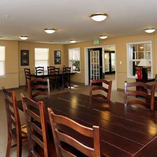 Spacious dining room with a large wooden table and multiple chairs.