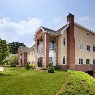 A modern residential building with a brick facade and well-maintained lawn.