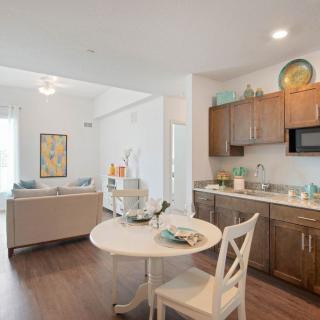 Modern open-concept kitchen and living area with wood flooring and stylish decor.