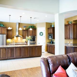 Modern kitchen with wooden cabinets and open living space.