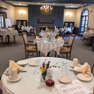 An elegant dining room with multiple tables set for a formal meal.