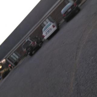 A quiet evening in a parking lot with several parked cars.