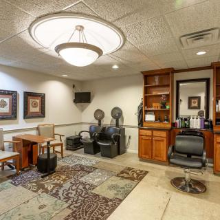 A well-furnished salon interior with chairs, mirrors, and stylish decor.