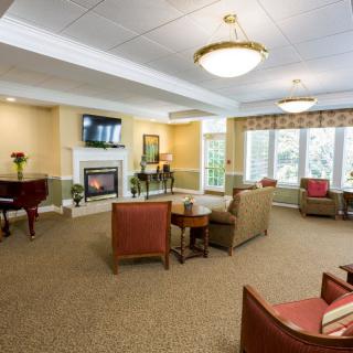 A cozy living room with comfortable seating, a fireplace, and a piano.