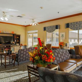 A cozy living room with comfortable seating and vibrant floral decorations.