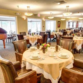 An elegantly set dining room with multiple round tables, ready for guests.