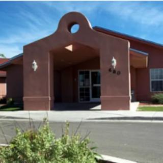 The image shows the exterior of a brick building with an arched entrance.