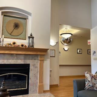 A cozy living room featuring a decorative fireplace, stylish furniture, and warm lighting.