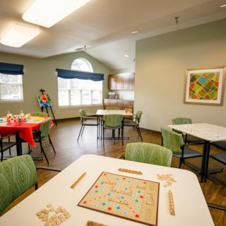 A community recreation room featuring tables with board games and chairs, offering a welcoming space for social activities.