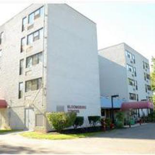 A view of a residential apartment building with multiple floors and red awnings.