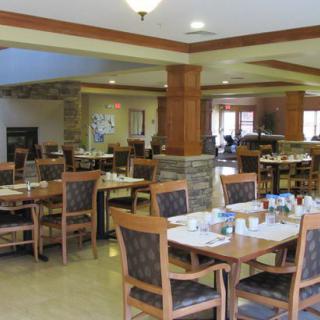 An empty restaurant dining area with neatly arranged tables and chairs.