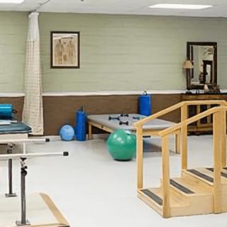 A physical therapy room equipped with exercise equipment and a set of stairs for rehabilitation exercises.