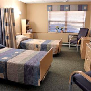 A well-organized hospital room with twin beds and modern furnishings.