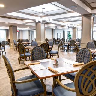 An empty restaurant dining area with neatly arranged tables and chairs.