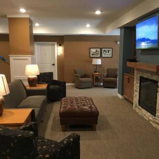 A cozy living room featuring a fireplace, comfortable seating, and a wall-mounted television.