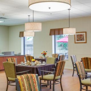 A clean and inviting dining area with tables, chairs, and soft lighting.