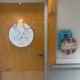 A creatively decorated door featuring a circular art piece and a wooden sign.