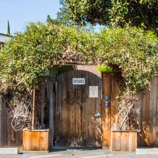 A wooden gate surrounded by lush greenery.
