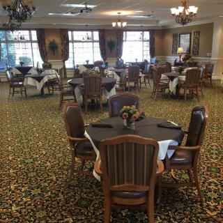 An elegant dining room set with round tables and upholstered chairs.